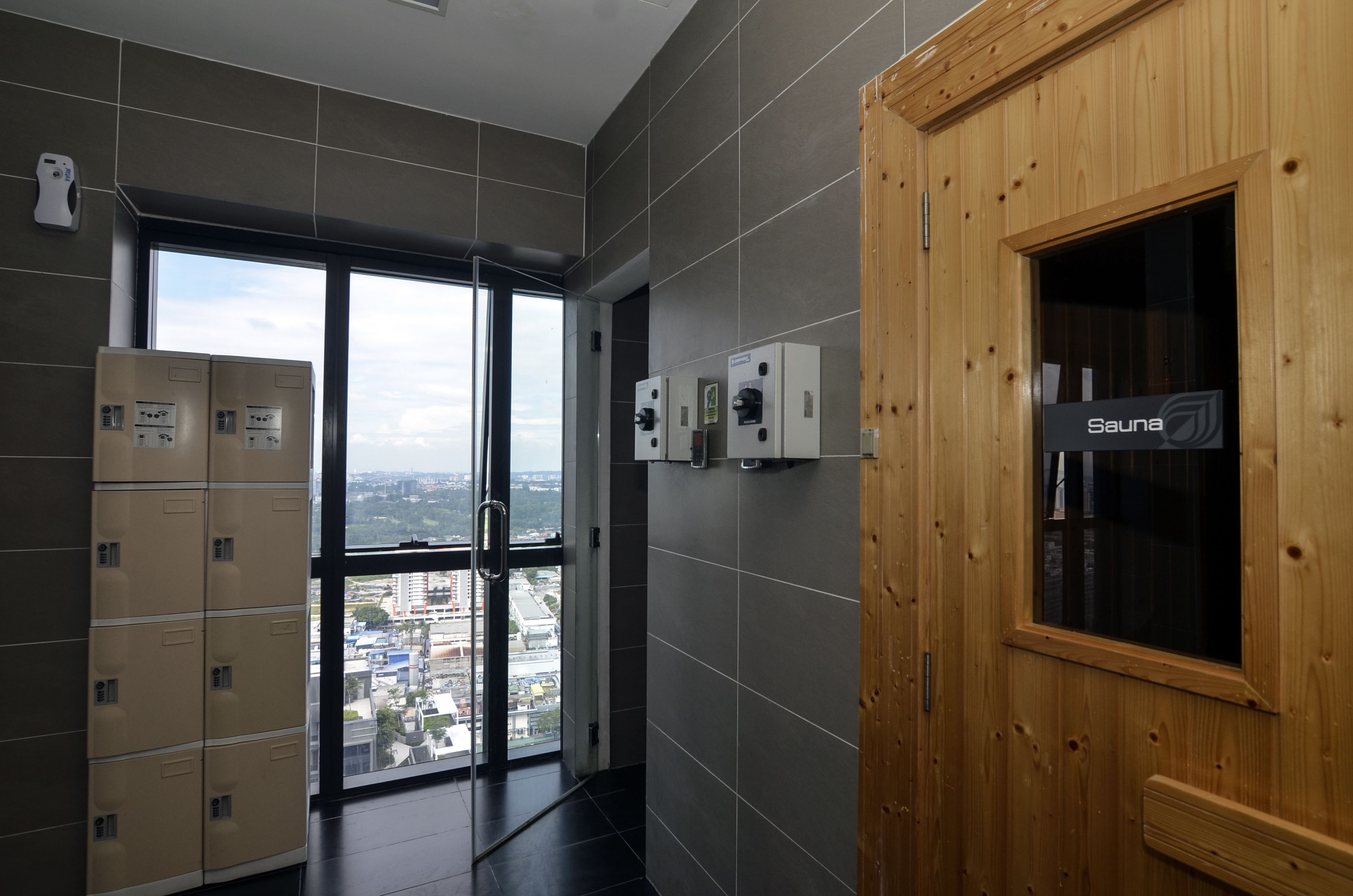 Un baño moderno con sauna, ventanas amplias y vista a la ciudad.