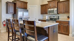 A kitchen with wooden cabinets, stainless steel appliances, and a marble countertop. - Private Pool, Mtn Views! Hurricane Group Getaway (Hurricane)