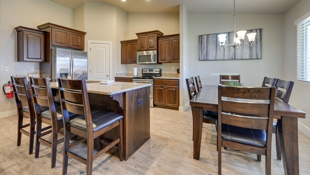 A modern kitchen with wooden cabinets, stainless steel appliances, and a central island with seating. - Private Pool, Mtn Views! Hurricane Group Getaway (Hurricane)
