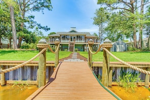 Cross a charming bridge to this two-story home surrounded by lush gardens and a tranquil atmosphere.