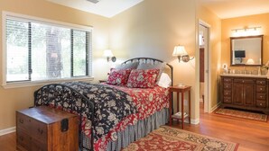 Une chambre à coucher avec un lit, une table de chevet, une lampe et une commode.