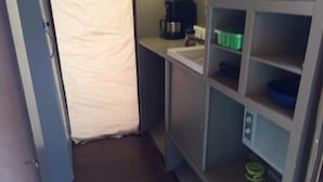A compact kitchenette with a coffee maker, a microwave, and a small refrigerator. - IDestinos Tayrona mobile home  (La Poza)
