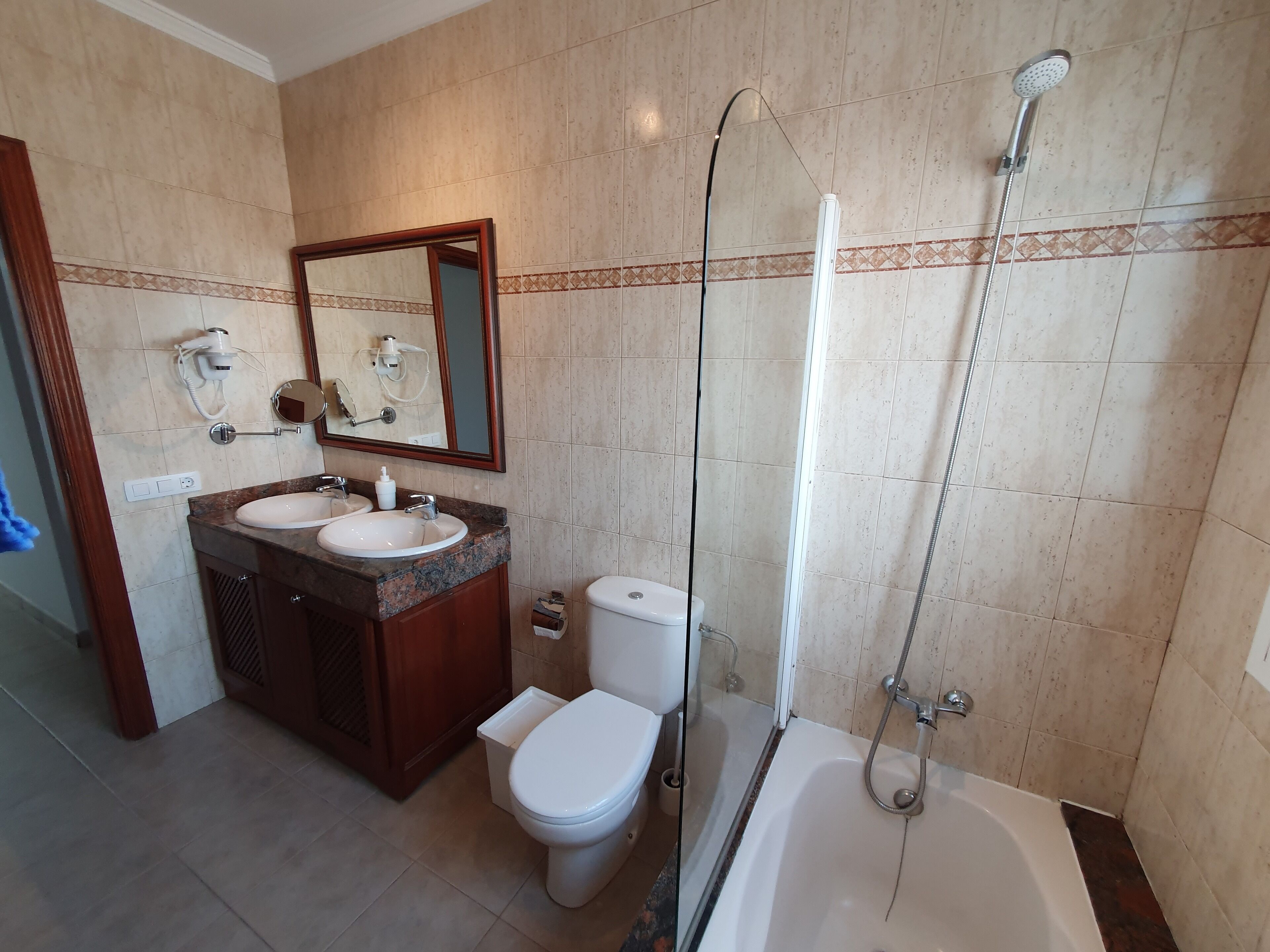 Een badkamer met een wastafel, toilet en bad.