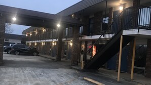 Ein Gebäude mit überdachtem Parkplatz, einer Treppe und einem sichtbaren Eingang.
