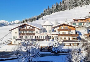 Un hotel con un cartel que dice 'ALMR AUCH' en una zona montañosa nevada.