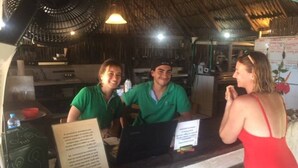 A restaurant with a thatched roof and a counter where people are seated. - IDESTINOS ROLLING HOUSE - PALOMINO (Palomino)