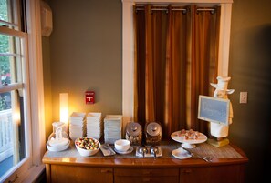 Enjoy a delicious breakfast spread with a variety of options, including cereal, fruits, and pastries, served on a table with bowls and utensils.