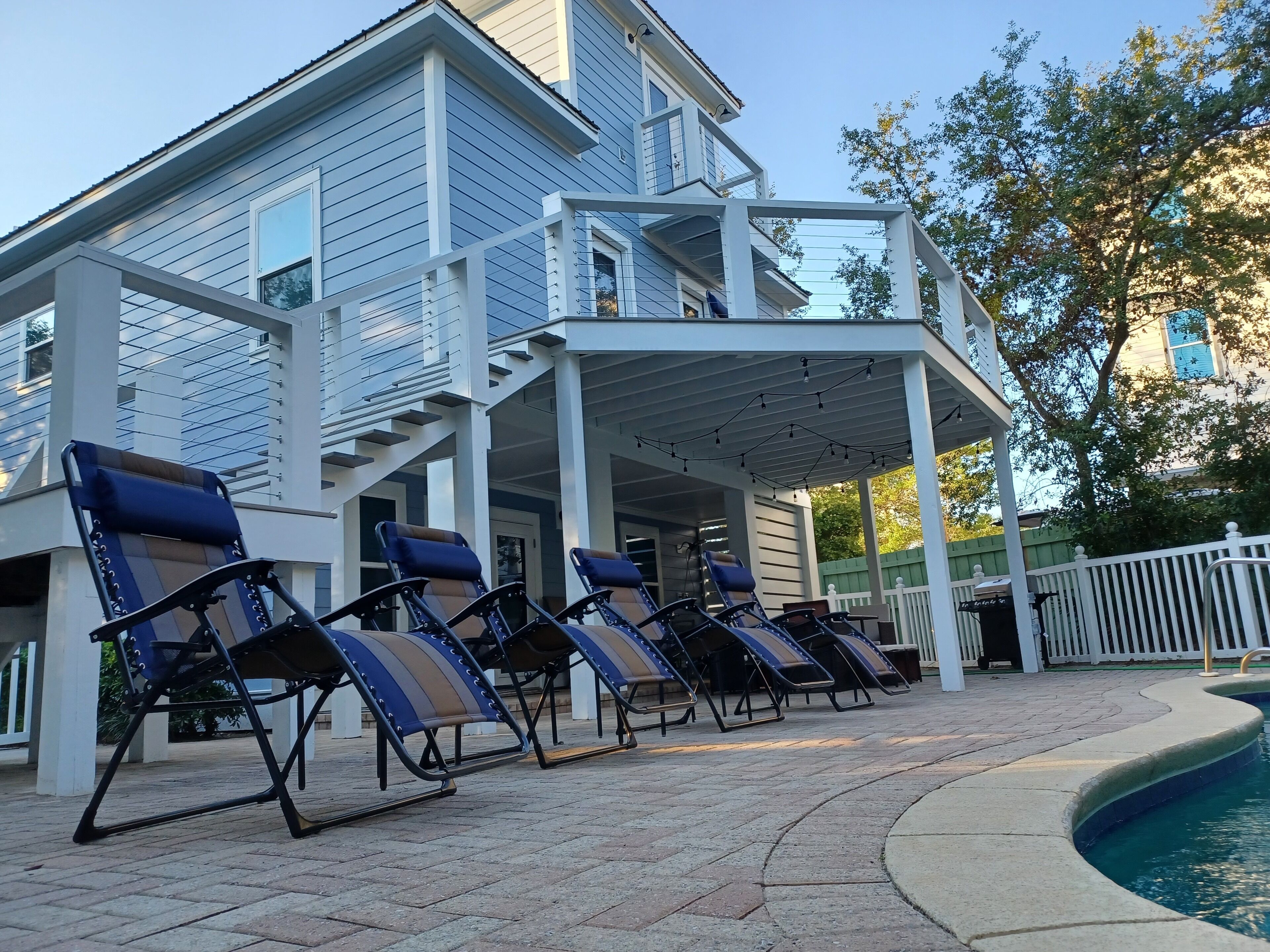 A poolside area with lounge chairs and a covered patio.
