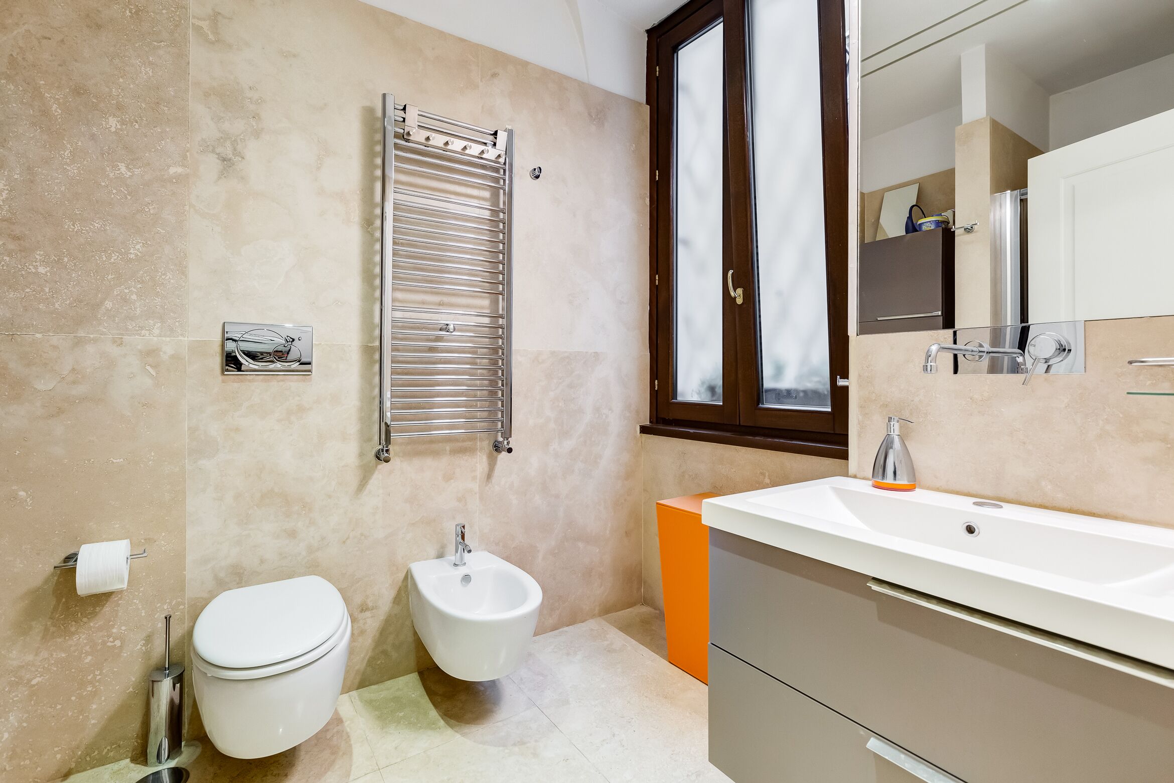 A modern bathroom with a toilet, bidet, and sink.