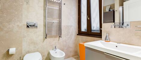 A modern bathroom with a toilet, bidet, and sink.