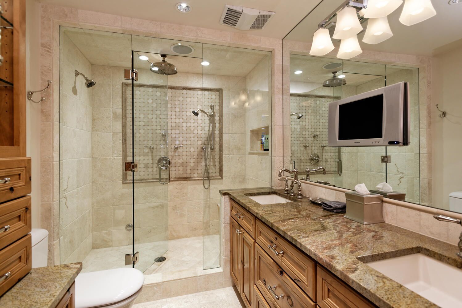 A modern bathroom with a glass-enclosed shower, a vanity with a sink, and a large mirror.