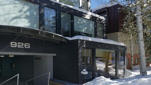 A modern building with a large glass facade, a visible entrance, and a snow-covered ground. - Pet Friendly & Luxurious 3 bedroom Aspen Condo (Aspen)