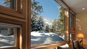 A room with a large window offering a view of a snowy landscape and parked cars. - Pet Friendly & Luxurious 3 bedroom Aspen Condo (Aspen)