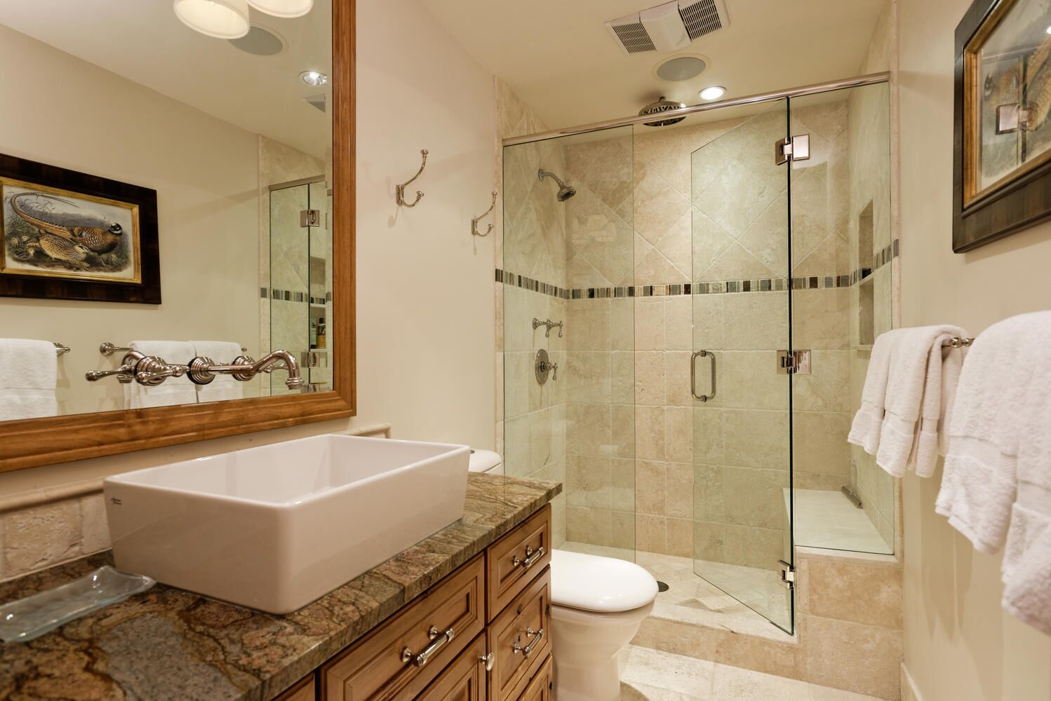 A modern bathroom with a large sink, vanity, and a glass-enclosed shower.