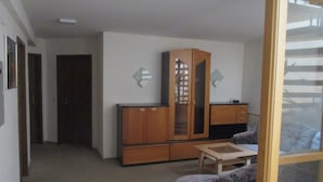 A room with a wooden cabinet, a small table, and a sofa. - Landhotel Lippach (Westhausen)