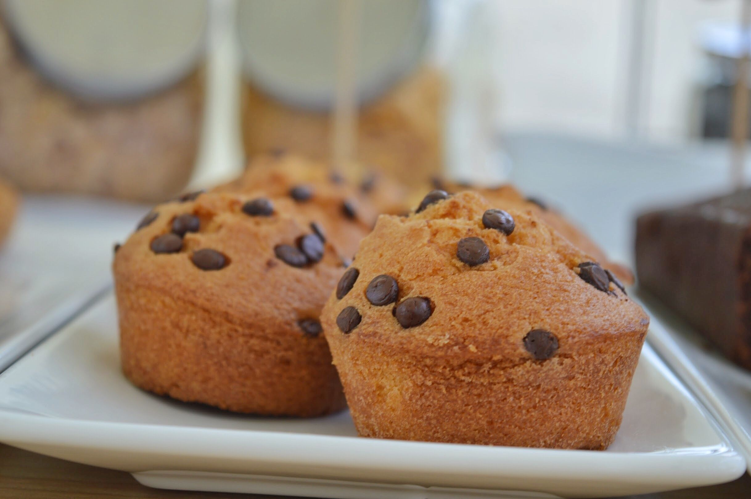 A plate with muffins topped with chocolate chips.