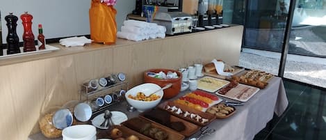 Un buffet de petit-déjeuner proposant une variété d’aliments, de condiments et une machine à café.