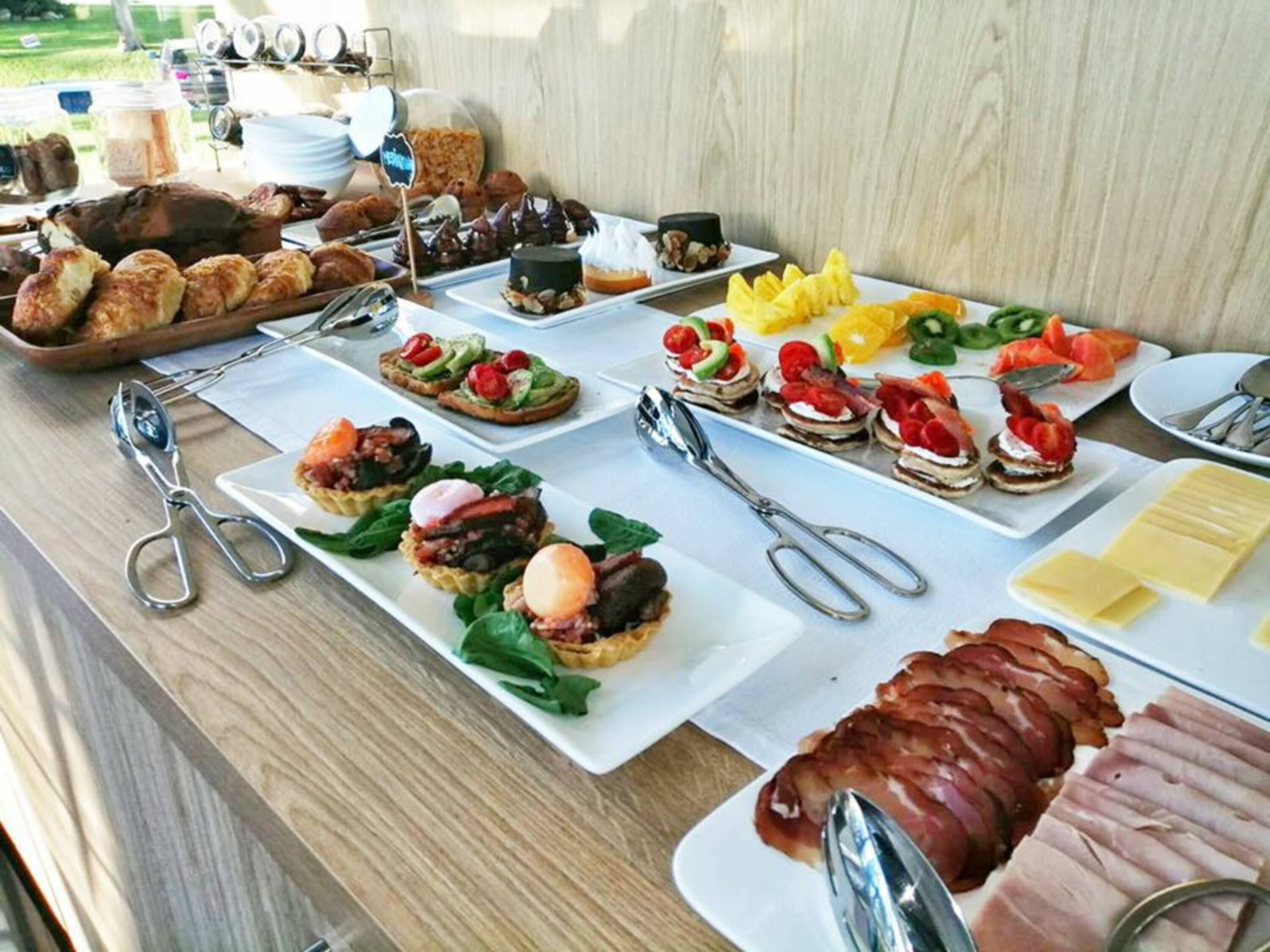 Ein Buffet mit verschiedenen Speisen, darunter Gebäck, Fleisch und Gemüse.