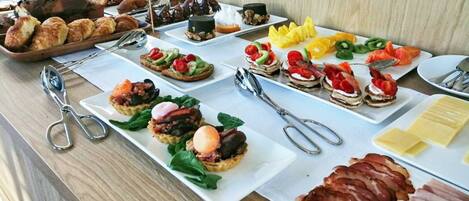 Una mesa de buffet con diversos alimentos, incluyendo pasteles, carnes y verduras.