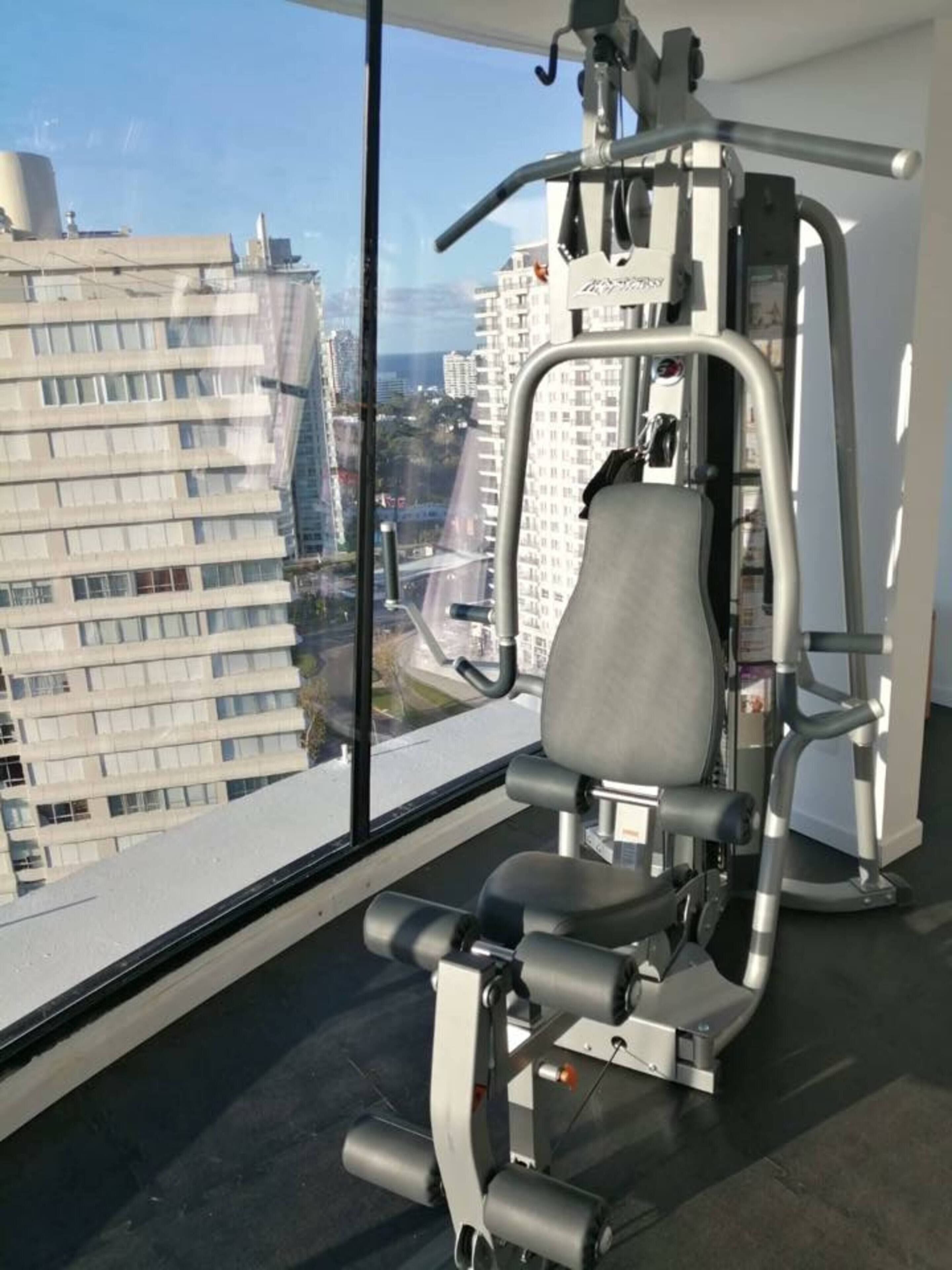 A gym with a view of a cityscape through large windows.