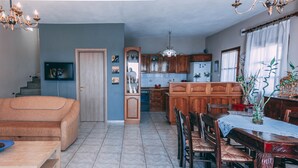 A spacious living room with a sofa and a dining table set for four. - Casa Di Bella (Volos)