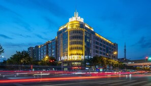 A multi-story hotel with a prominent 'AVANDER' sign, featuring a modern architectural design with a curved facade and illuminated signage.