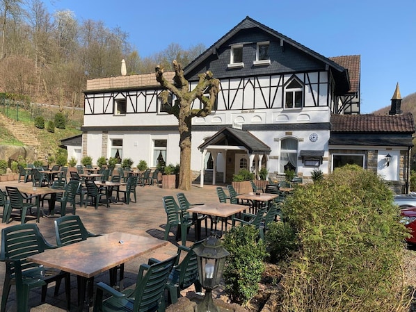A traditional building with a terrace cafe area featuring outdoor seating.