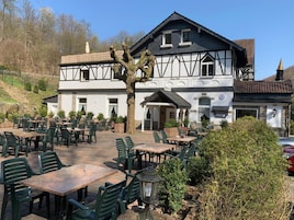 Un edificio tradicional con un café en terraza y asientos al aire libre.