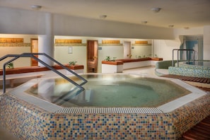 A hot tub area with a tiled floor, wooden benches, and a wooden railing.
