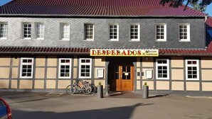 A building with a sign reading "DESPERADOS" and a bicycle parked outside. - Desperados Hotel (Bergen)
