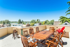 Enjoy a meal on the rooftop terrace with views of the surrounding houses and trees.