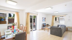 A spacious living area with a dining table, sofa, and a TV. - Protaras Villa PV5 - Modern 3BDR Central Protaras Villa with Private Pool (Unknown)