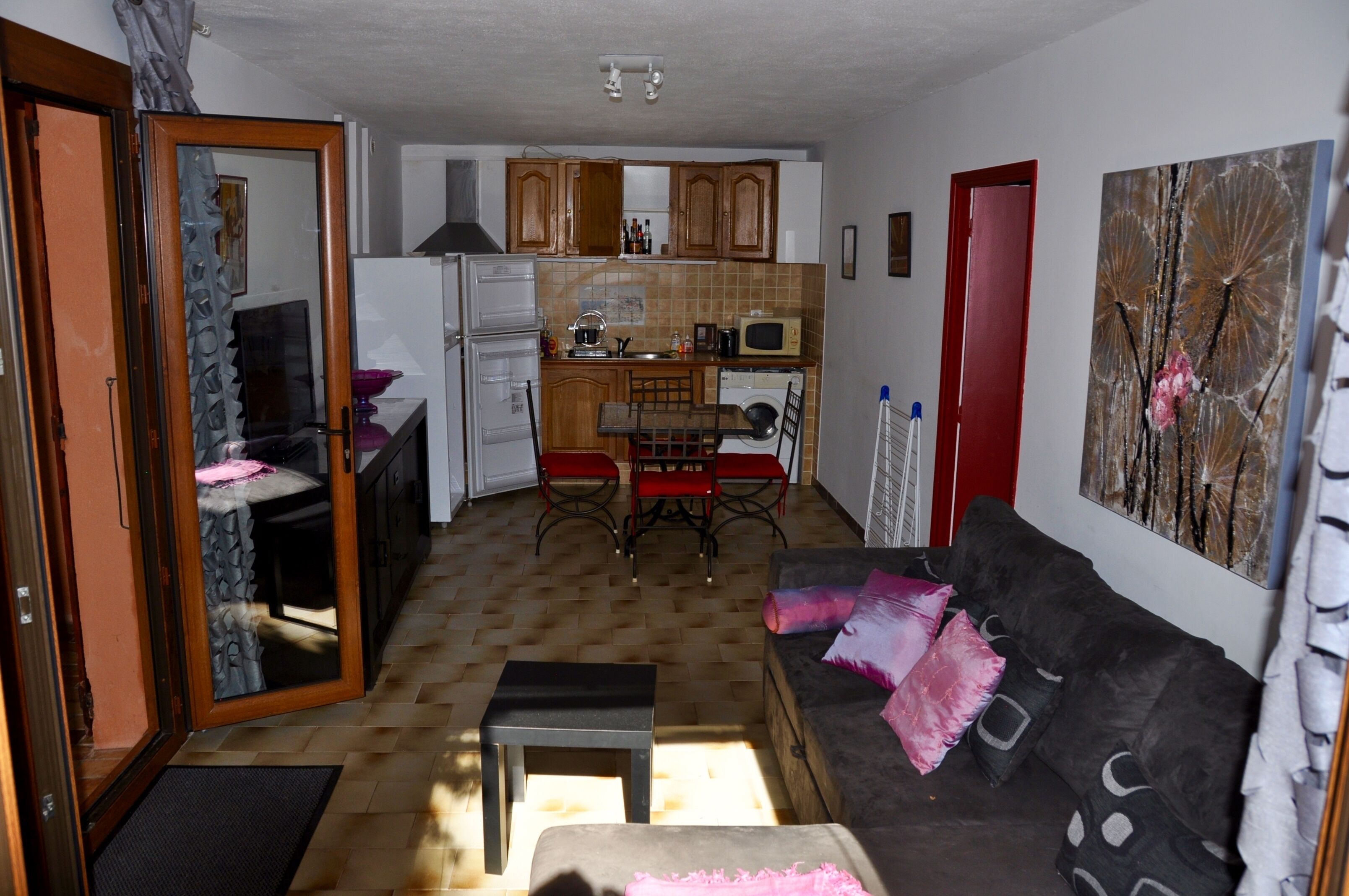 Un espacio habitable pequeño con kitchenette, comedor y sofá.