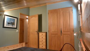 Une chambre à coucher avec un lit, une armoire en bois et une commode.