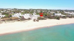 Uma área costeira com uma praia e uma fileira de edifícios brancos.