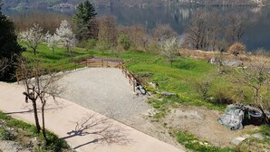 Una vista pintoresca de un lago con un puente de madera, rodeado de campos verdes y árboles.