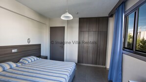 A modern bedroom with a bed, a wardrobe, a window with curtains, and a ceiling light.