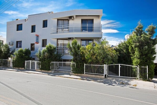 Un edificio moderno de dos pisos con un balcón en el nivel superior.