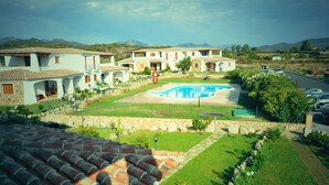 A residential complex with multiple houses, a swimming pool, and a well-maintained garden.