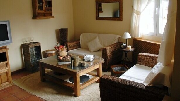 A cozy living room with a sofa, a coffee table, a TV, and a cabinet.