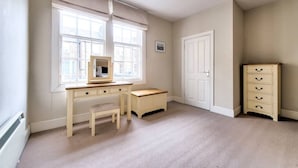 A room with a desk, chair, and a dresser. - Spacious Apartment in Edinburgh's City Centre (Edinburgh)