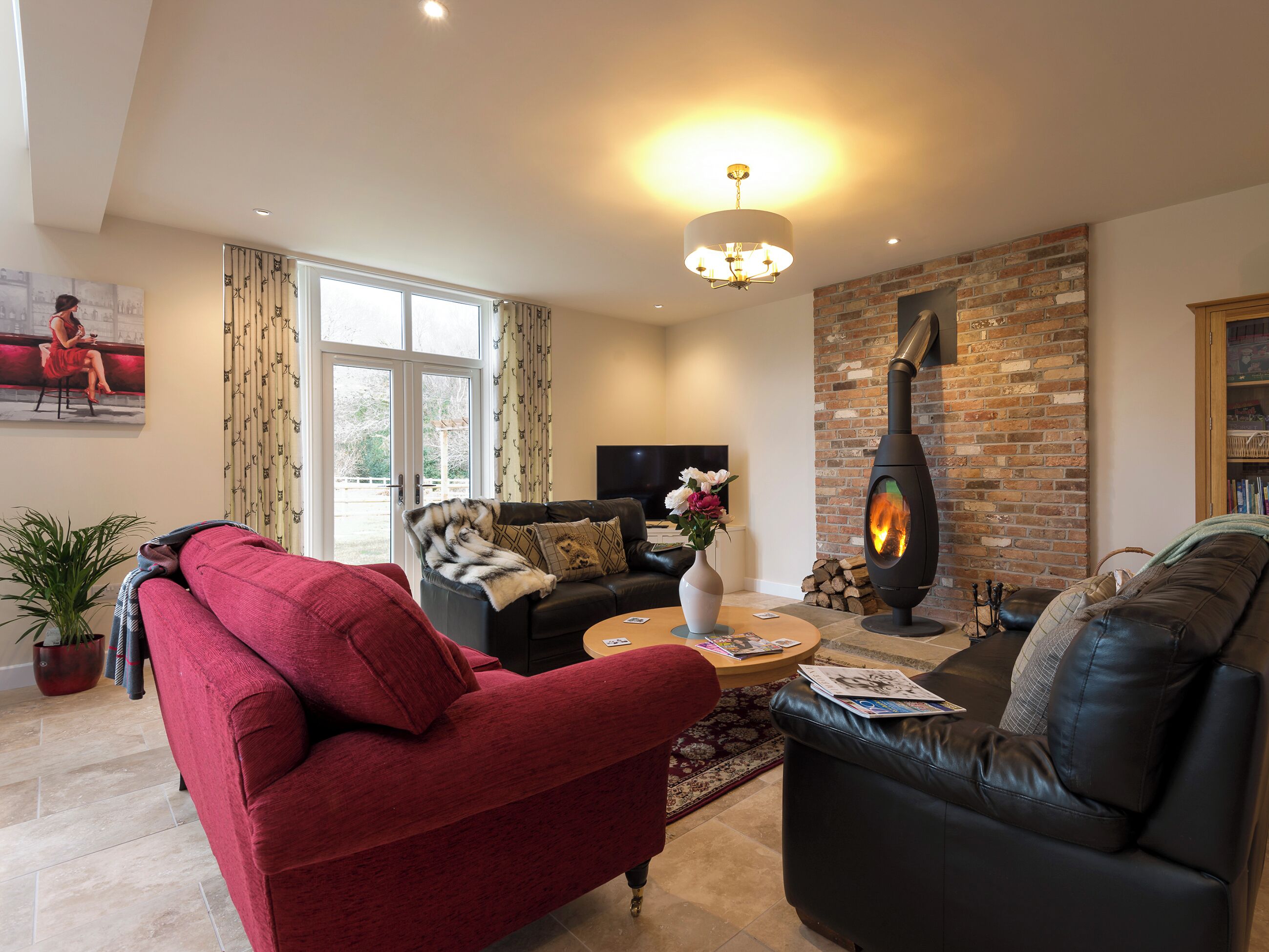 Una sala de estar con chimenea, sofás de cuero, una mesa de centro y un televisor.