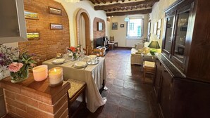 A dining area with a brick wall, wooden beams, and a table set for a meal. - Beautiful apartment for 6 people with WIFI, TV and terrace (Lucca)