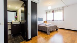 Een hotelkamer met een bed, een bedlampje en een raam met gordijnen.