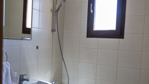 Une salle de bain avec un lavabo, des toilettes et une douche.