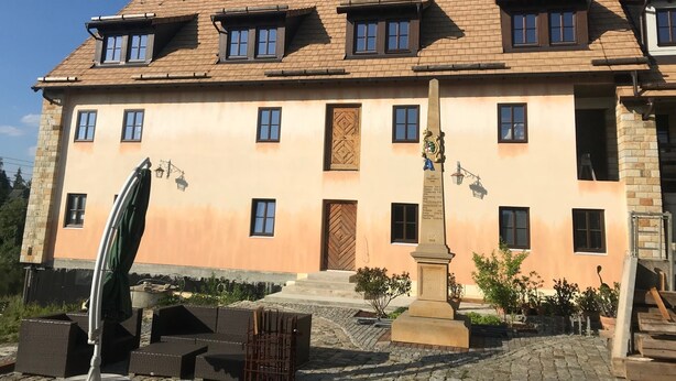 A two-story building with a tiled roof, multiple windows, and a central entrance. - Holiday apartment PENZLIN in a maritime style near Radeberg (Leppersdorf)