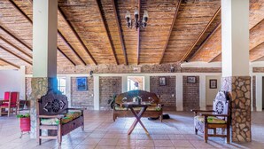 A spacious lobby with a high wooden ceiling, stone pillars, and a central wooden bench. - Collection O Posada Terraza (Tequila)