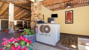 A reception area with a stone pillar, a wooden bench, and a fire extinguisher. - Collection O Posada Terraza (Tequila)