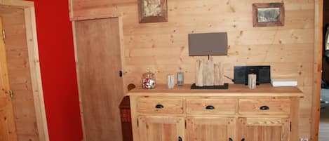 A wooden cabinet with drawers and a small table with a lamp and a clock.