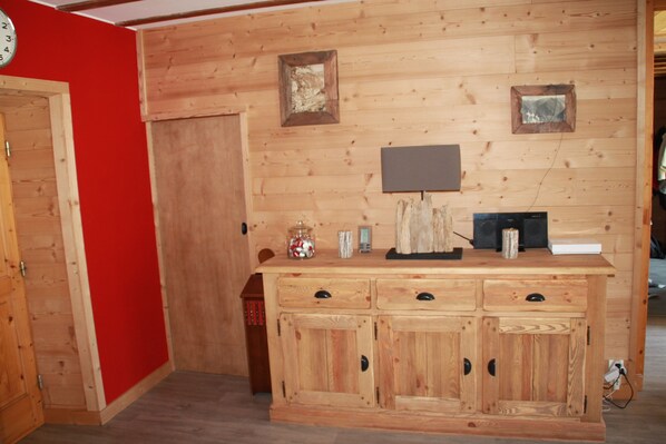 Un meuble en bois avec des tiroirs et une petite table sur laquelle se trouvent une lampe et une horloge.